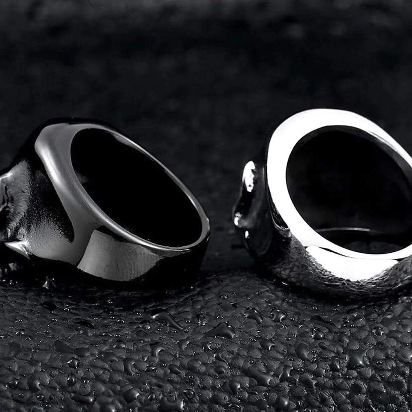 Top side view of black and silver polished skull rings with visible inner band detail showcasing stainless steel ring construction