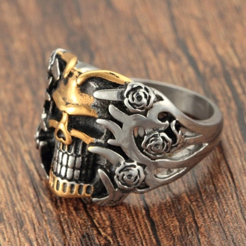 Dual-tone skull rose ring front oblique view on wooden surface, integrated skull and rose design with matte metal finish, 10mm surface width gothic statement piece