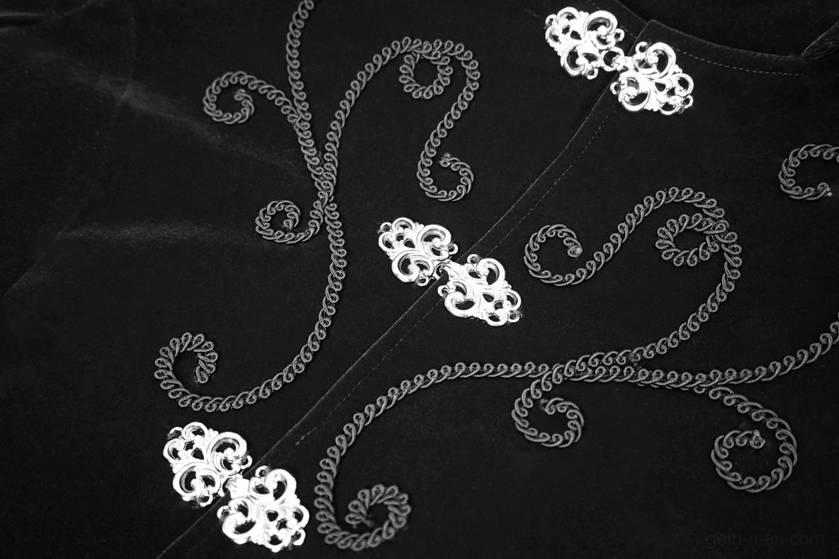 Steampunk coat embroidery detail showing ornate curved scroll patterns with decorative metal buttons