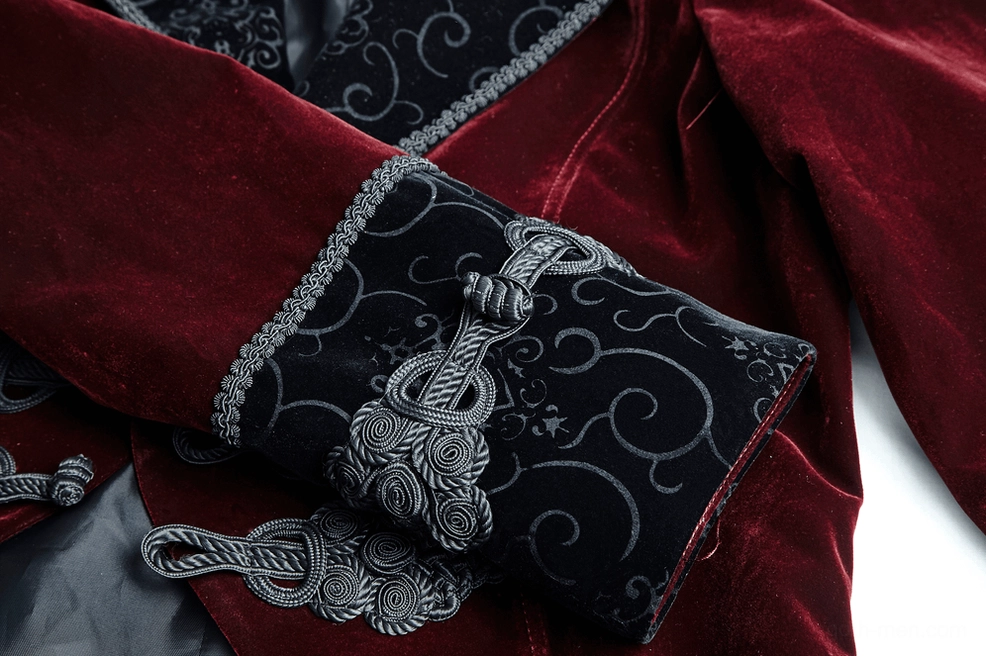 Close-up flat lay of tailcoat cuff showing swirl embroidery pattern and decorative frog button closure