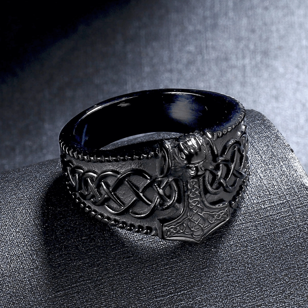 Front facing matte black gothic ring displaying engraved Celtic knot and Thor's hammer symbolism