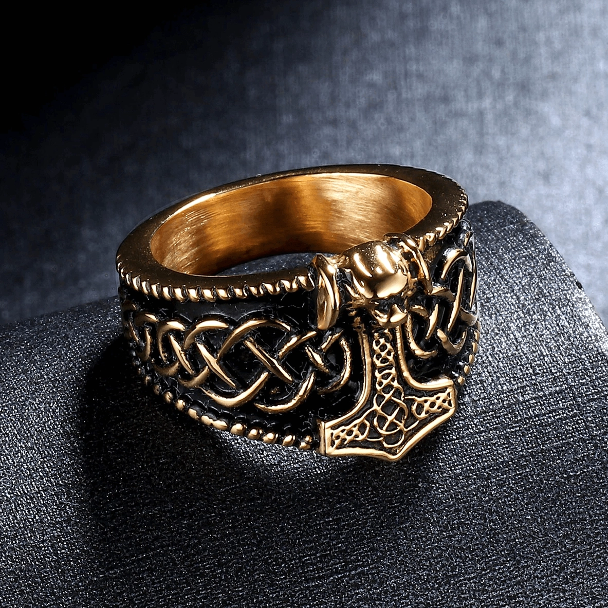 Two-tone gold and black Thor's hammer gothic ring front oblique perspective on gray display