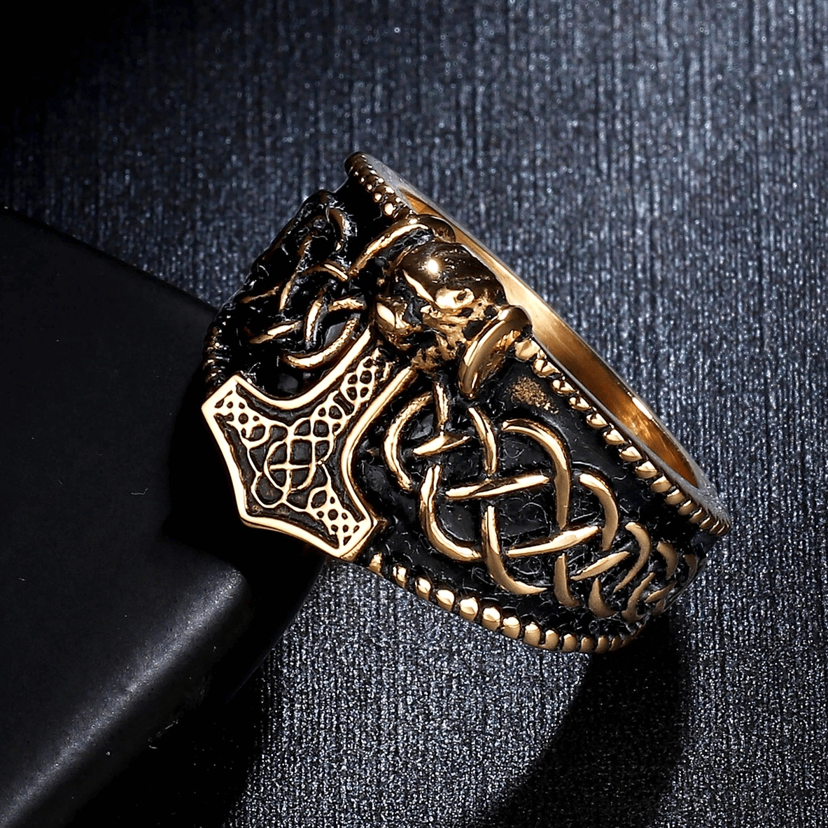 Two-tone gold and black gothic men's ring side view showcasing Mjolnir and skull design contrast