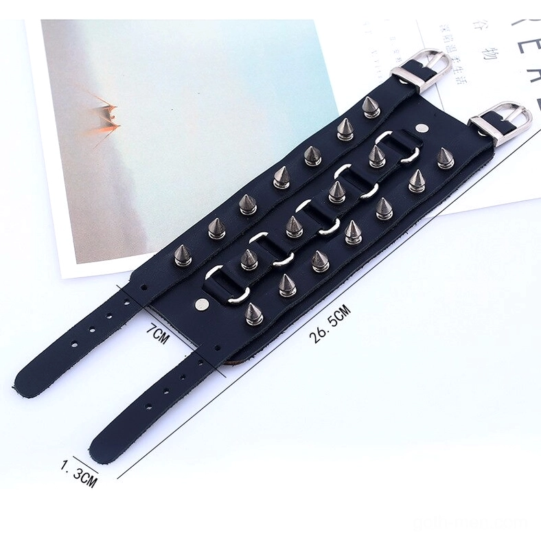 Flat lay top-down view of gothic leather cuff with measurement scale showing spike density and metal hardware positioning