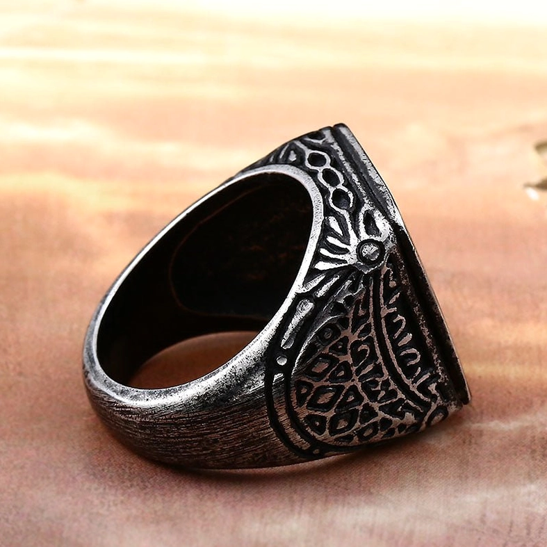 Vintage distressed black metal signet ring side view showing intricate floral carvings and aged patina