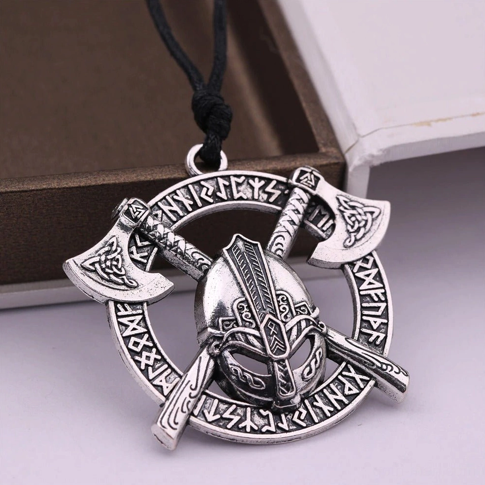 Dual crossed axes gothic pendant with engraved symbols on mixed textile background