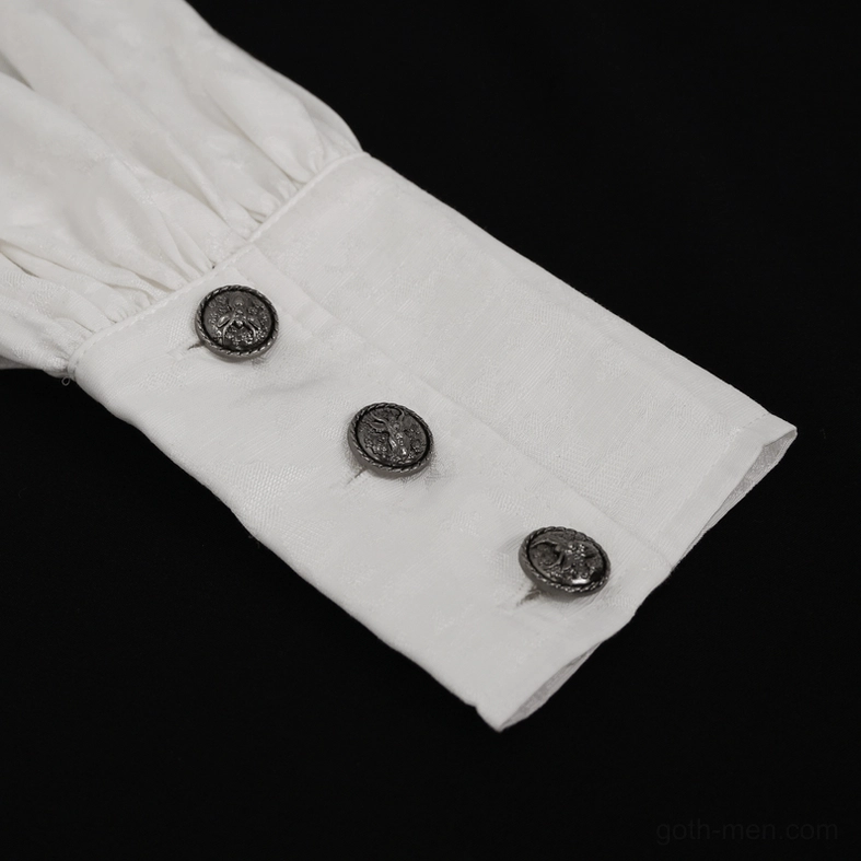 Close-up of white gothic shirt cuff showing three vintage metal buttons, tailored cuff construction, and button hole detail against dark background