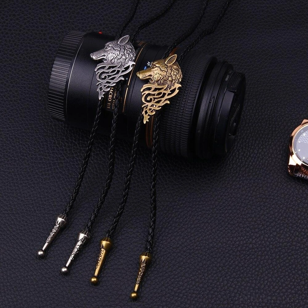 Wolf head choker necklace styled on dark leather background with accessories, gothic pendant jewelry flat lay photography