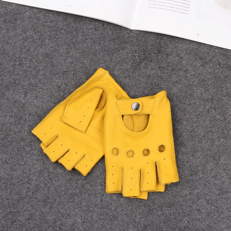 Yellow half-finger leather gloves with snap button closure and fingerless gothic aesthetic on textured background